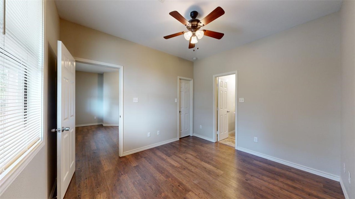 821 Ave B College Station, TX 77840 - Photo 27 of 33 an empty room with wooden floor and a ceiling fan