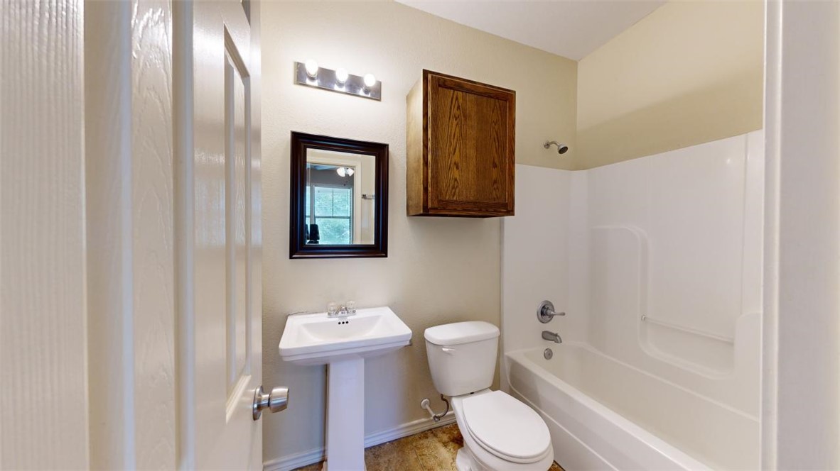 821 Ave B College Station, TX 77840 - Photo 28 of 33 a white toilet sitting next to a bathroom sink and a shower