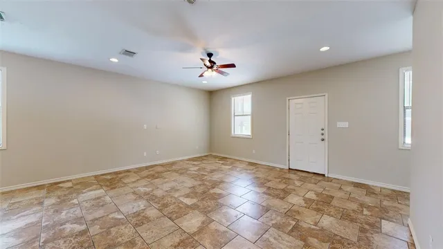 a view of kitchen with stainless steel appliances kitchen island granite countertop a refrigerator and cabinets