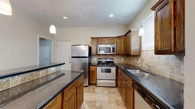 a kitchen with kitchen island a sink stainless steel appliances and cabinets