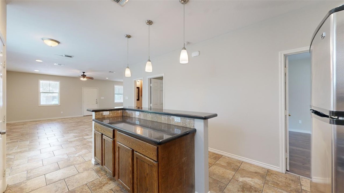 821 Ave B College Station, TX 77840 - Photo 9 of 33 a kitchen with kitchen island a sink stainless steel appliances and cabinets