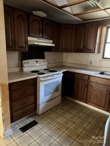 a kitchen with granite countertop a refrigerator and a sink