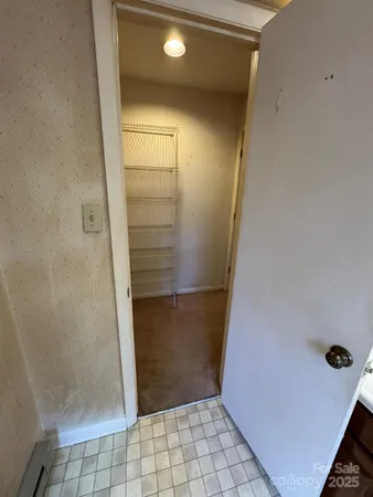 a view of a hallway with a livingroom and a bathroom