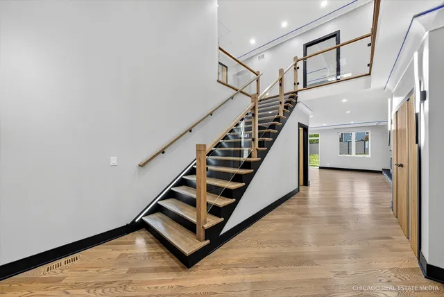 a view of a hallway with wooden cabinets and staircase