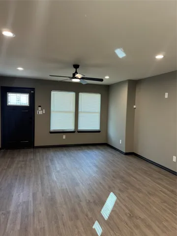 an empty room with wooden floor and window