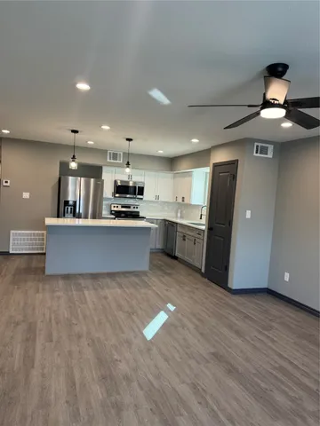 a large kitchen with stainless steel appliances granite countertop a stove and a refrigerator