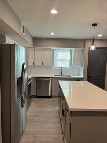 a kitchen with stainless steel appliances a refrigerator sink and cabinets