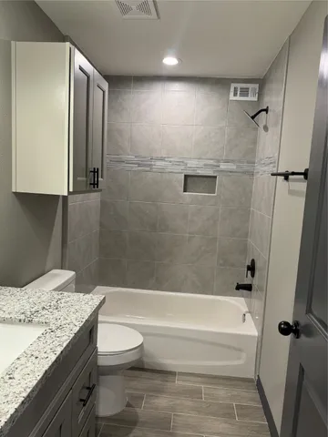 a bathroom with a granite countertop sink toilet and shower
