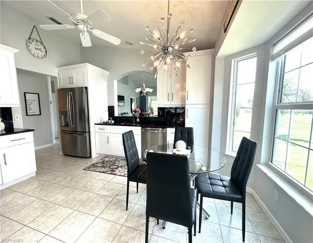 a dining room with furniture a chandelier and wooden floor