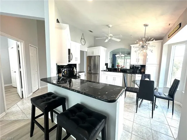 a kitchen with a dining table chairs and granite counter tops