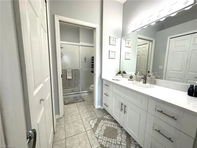a spacious bathroom with a shower a sink and a mirror