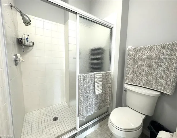 a white toilet sitting next to a bathroom shower