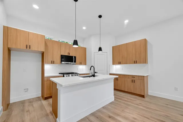 a kitchen with stainless steel appliances granite countertop a sink a stove and a refrigerator