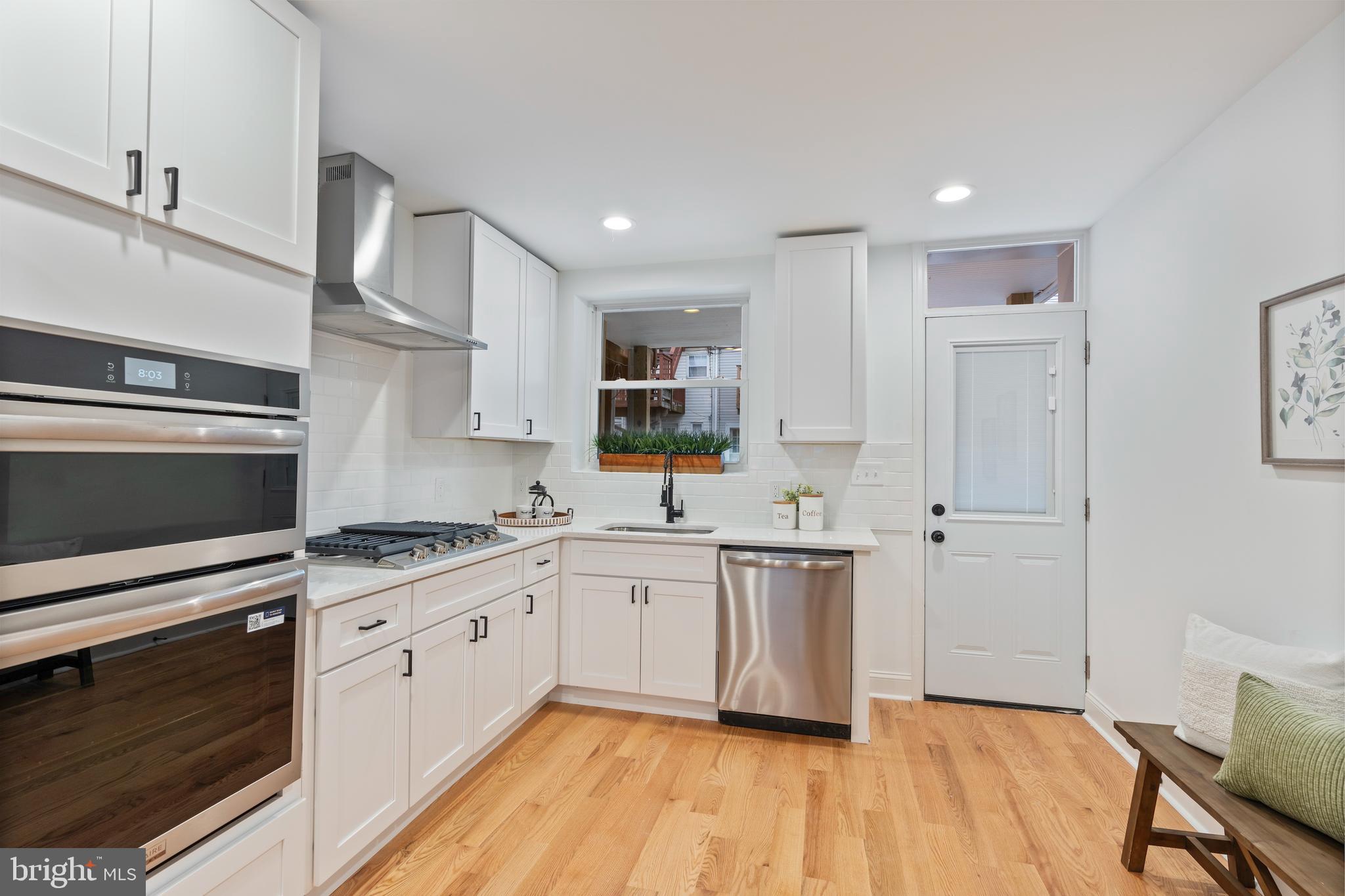 1352 Andre Street Baltimore, MD 21230 - Photo 8 of 52 a white kitchen with stainless steel appliances granite countertop a stove and a sink
