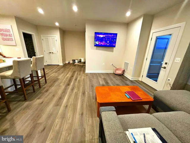 a living room with furniture and a wooden floor