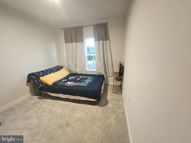 a bed sitting in a bedroom next to a window