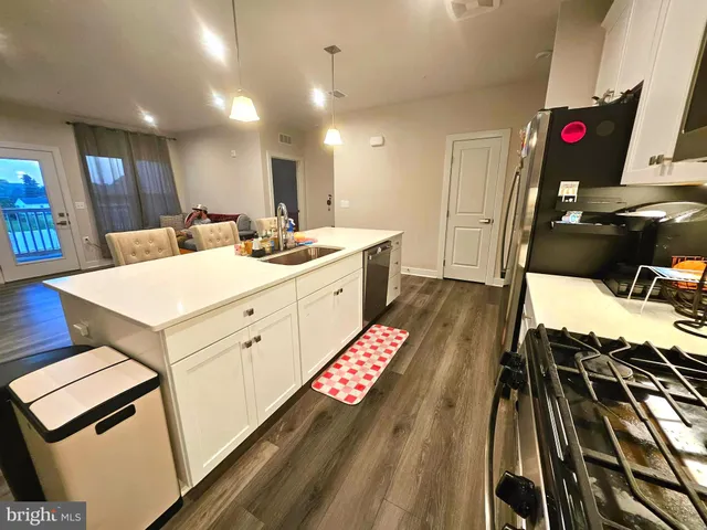 a kitchen with a sink a stove and chairs