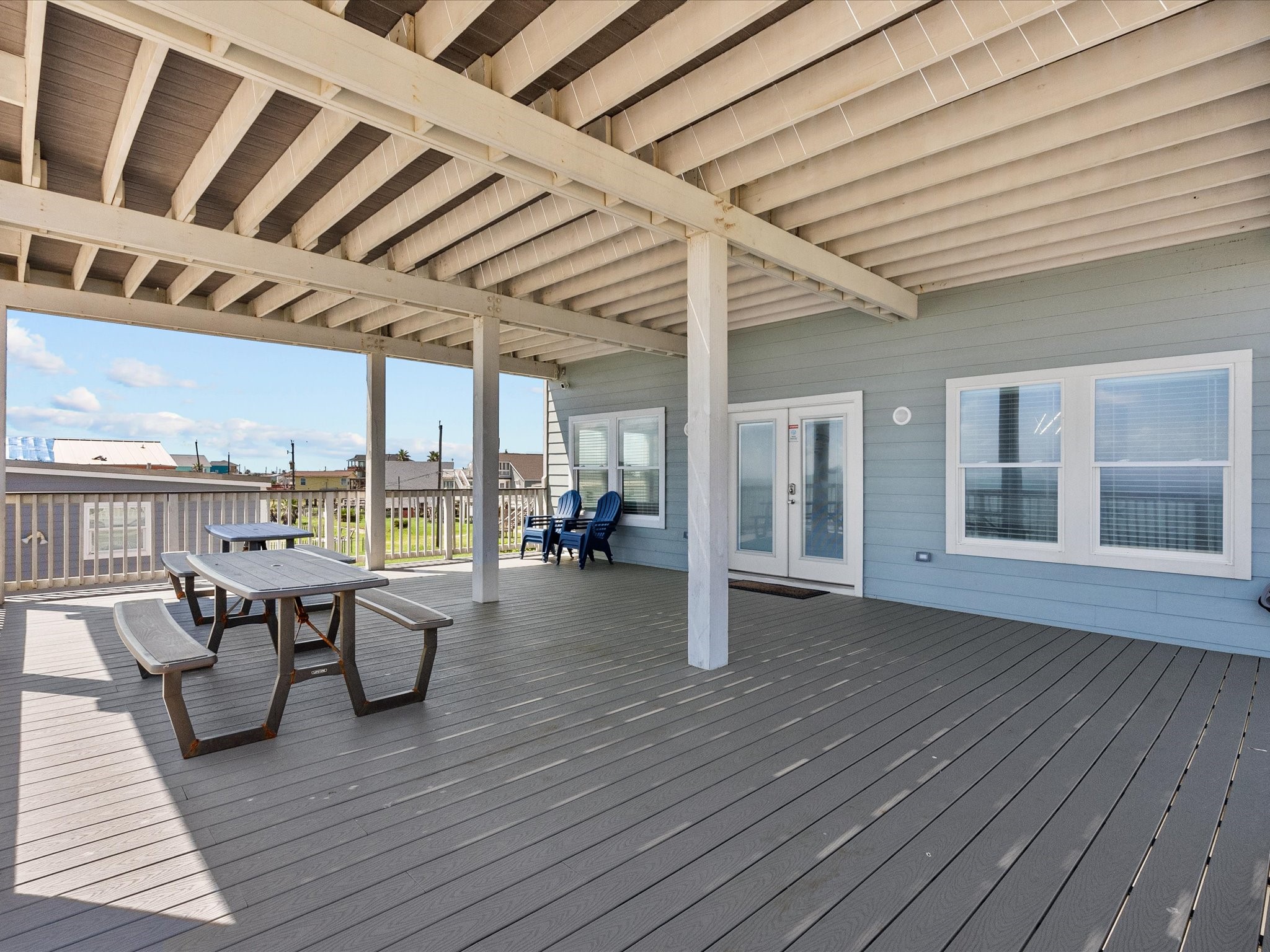 718 Beach Drive Surfside Beach, TX 77541 - Photo 45 of 49 Enjoy outdoor living on this spacious covered deck, featuring durable flooring and ample seating for relaxation and entertaining, with scenic neighborhood views.