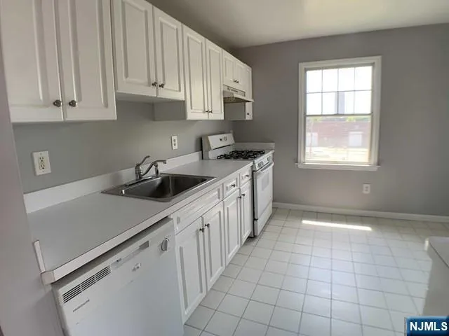 a kitchen with a sink cabinets and window