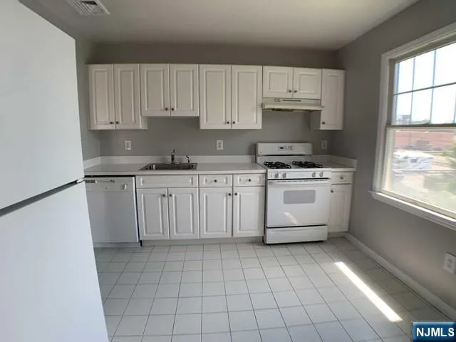 a kitchen with a stove sink and cabinets