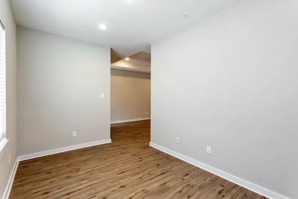 an empty room with a window and wooden floor