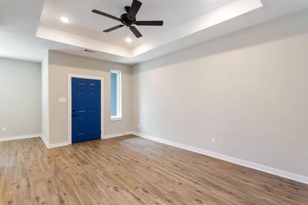 an empty room with wooden floor and windows
