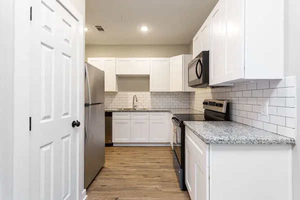a kitchen with stainless steel appliances granite countertop a sink stove and cabinets