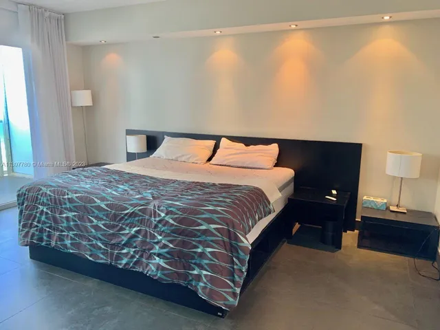 a large bed sitting in a bedroom next to a lamp