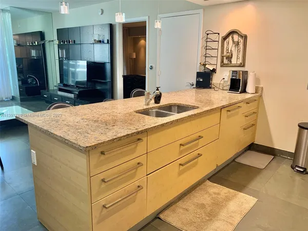 a living room with furniture and a refrigerator