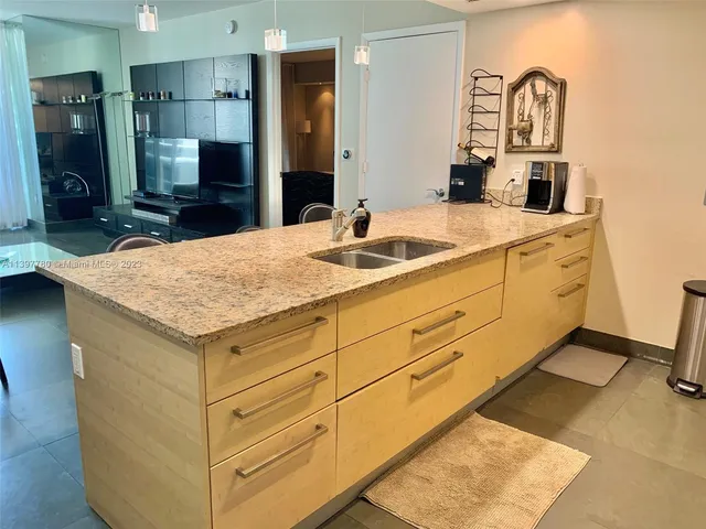 a living room with furniture and a refrigerator