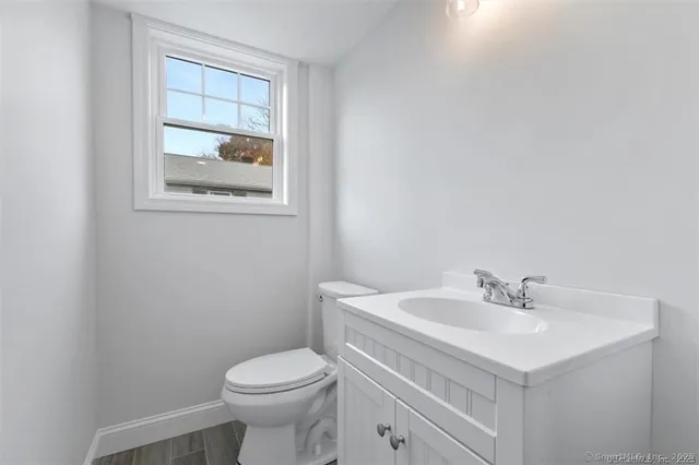 a bathroom with a sink toilet and a mirror