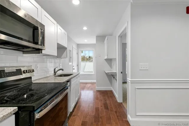 a kitchen with stainless steel appliances granite countertop a stove sink and microwave