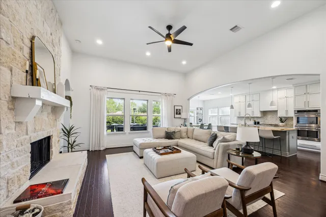 a living room with furniture fireplace and a large window