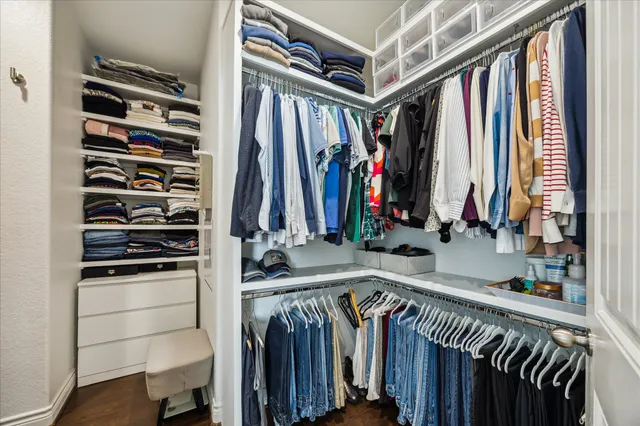 a view of walk in closet with clothes and shoes