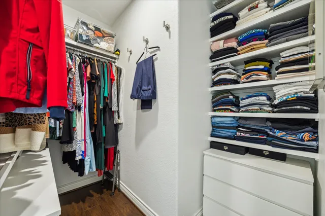 a view of walk in closet with clothes and shoes