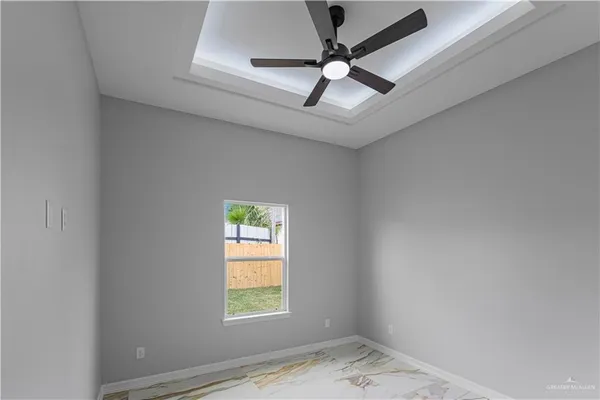 an empty room with a window and a ceiling fan