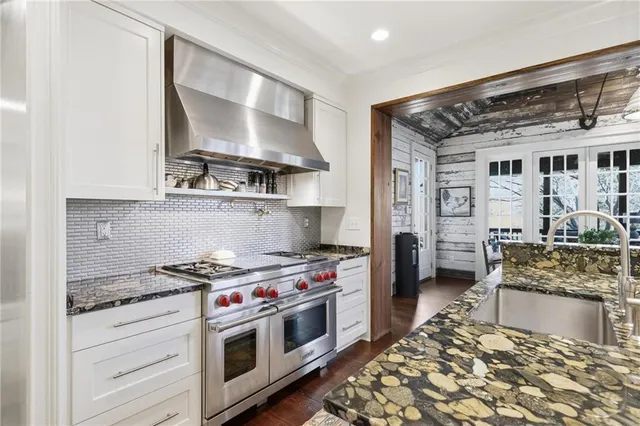 a kitchen with stainless steel appliances a stove a sink and cabinets