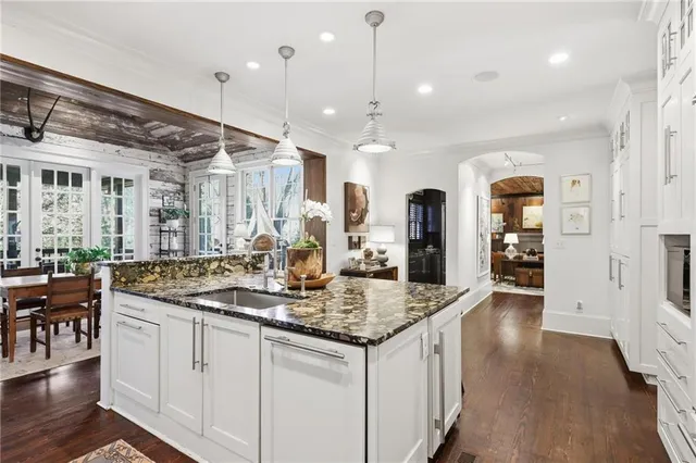 a kitchen with granite countertop a sink a counter space appliances and cabinets