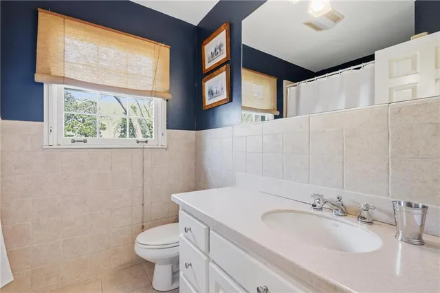 a bathroom with a sink a toilet and a mirror