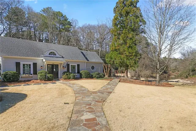 a front view of a house with a yard and trees
