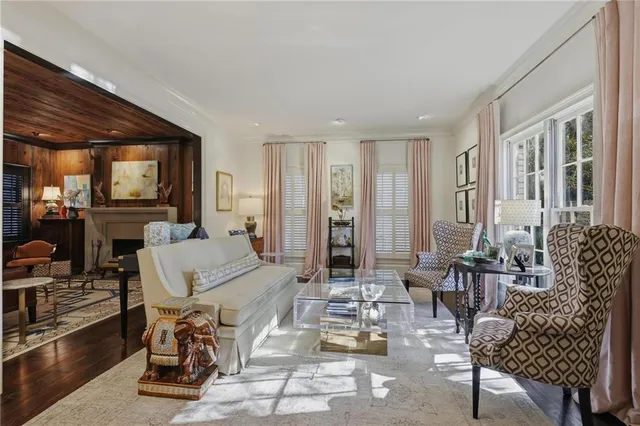 a living room with furniture and a dining table with wooden floor