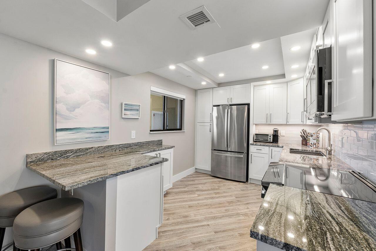 200 Ocean Trail Way, Unit 602 Jupiter, FL 33477 - Photo 13 of 50 a kitchen with stainless steel appliances granite countertop a sink stove and refrigerator