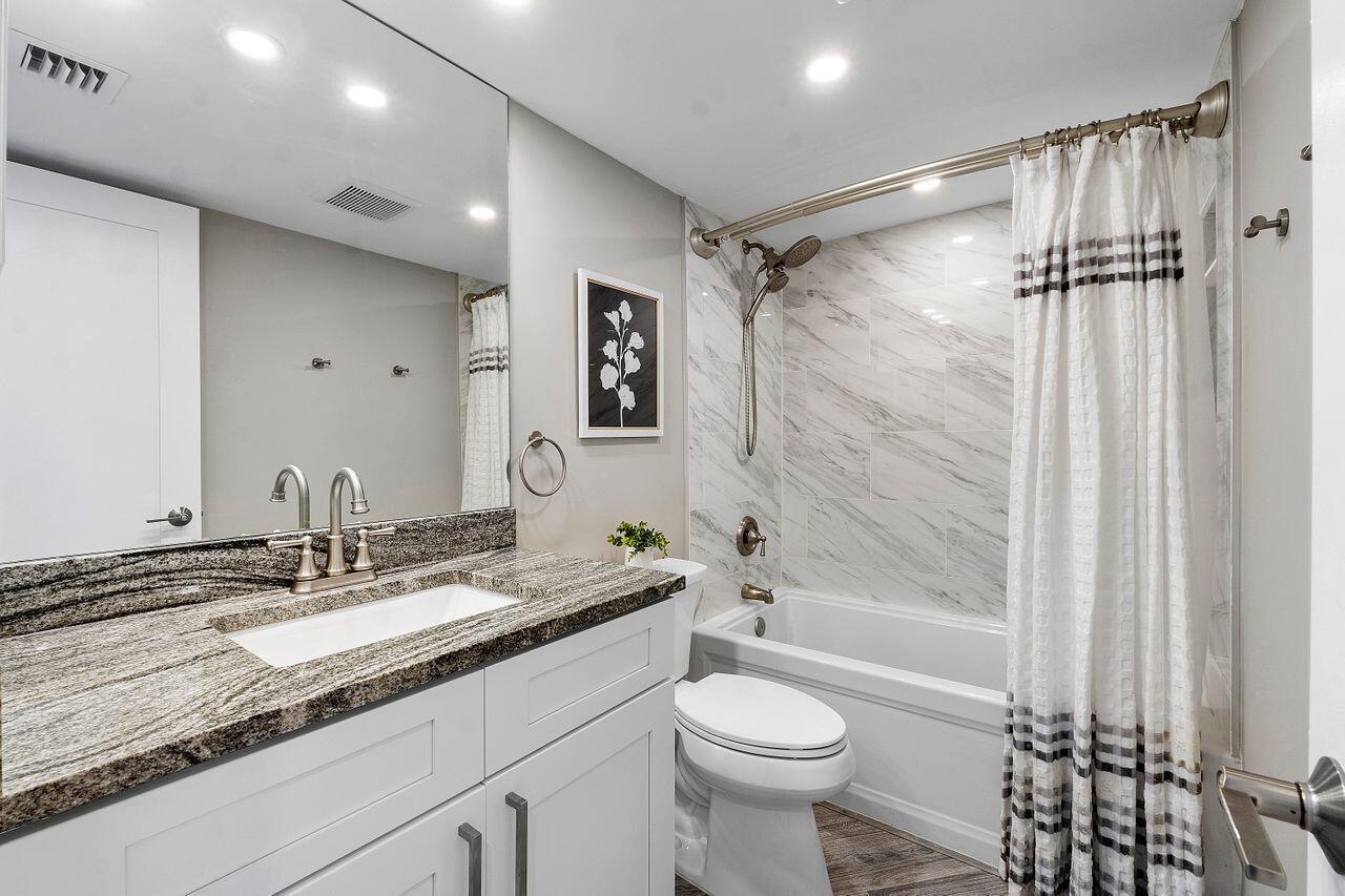 200 Ocean Trail Way, Unit 602 Jupiter, FL 33477 - Photo 30 of 50 a bathroom with a granite countertop sink a toilet a mirror and shower