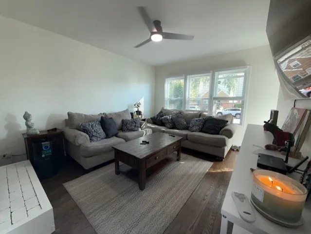 a living room with furniture a flat screen tv and a large window