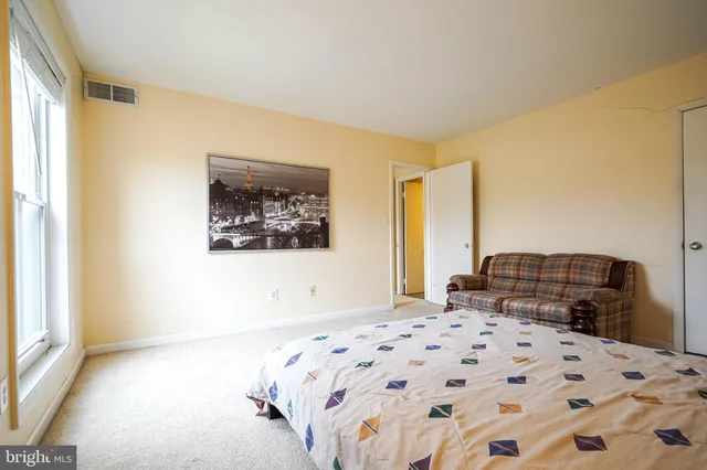 a bedroom with a bed and a painting on the wall