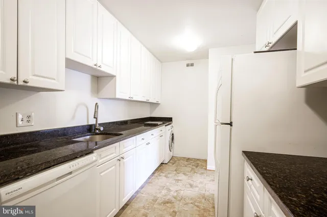 a kitchen with granite countertop a sink and a stove