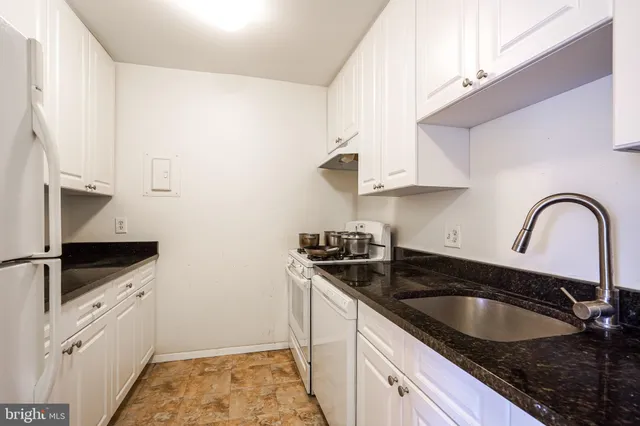 a kitchen with granite countertop a sink stainless steel appliances and cabinets