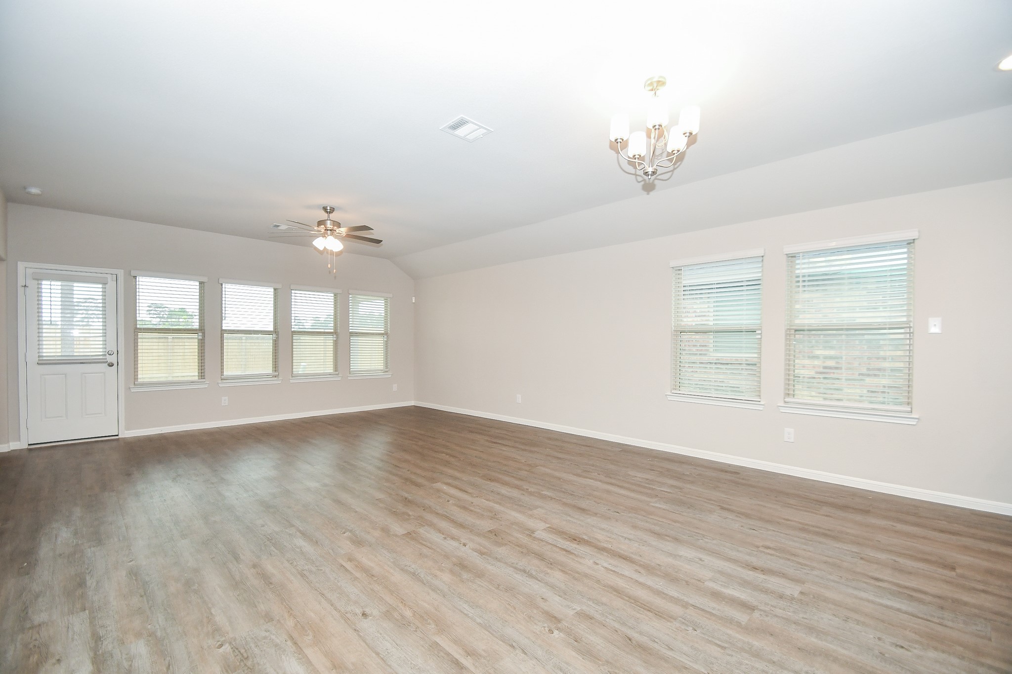 17811 Chartertree Lane Tomball, TX 77377 - Photo 13 of 32 an empty room with wooden floor chandelier and windows
