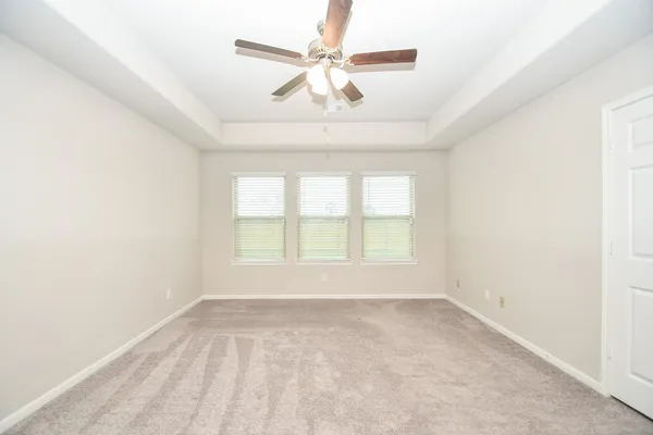 an empty room with a window and a fan