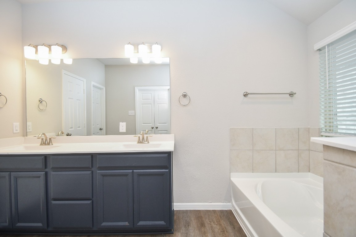 17811 Chartertree Lane Tomball, TX 77377 - Photo 18 of 32 a bathroom with a tub a sink and mirror
